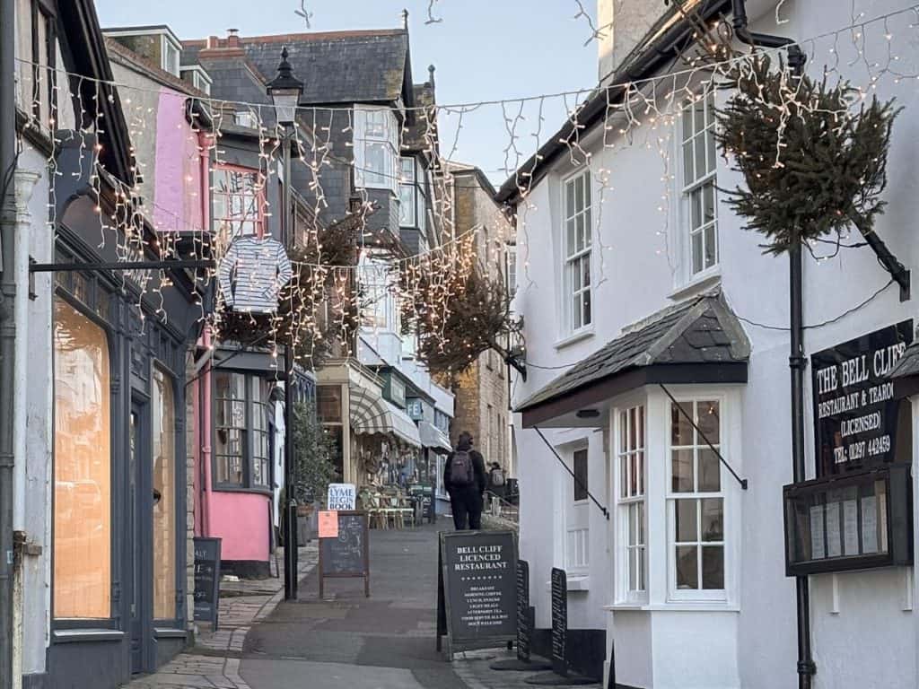 Tearooms and shops on street in Lyme Regis decorated in Christmas lights