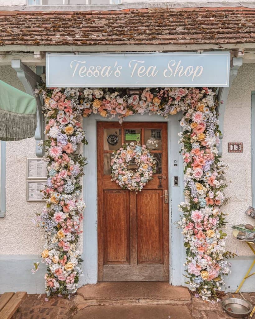 The beautiful doorway of Tessa's Tea Shop decorated with flowers in Dunster, Somerset