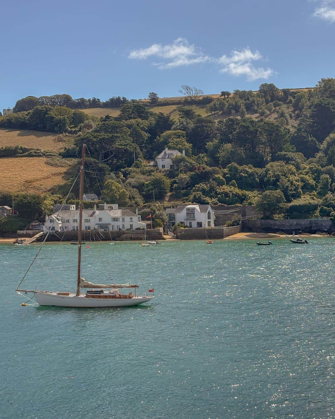 Salcombe water glistening on a sunny day with boat
